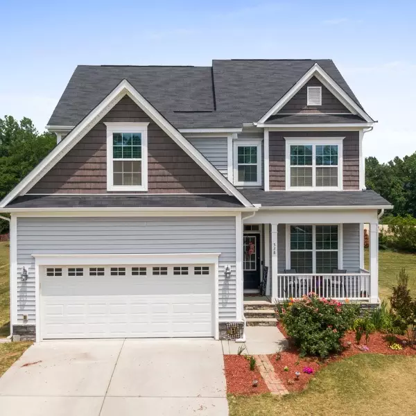Modern two-story house with landscaped yard and driveway during clear weather Modern two-story house with landscaped yard and driveway during clear weather