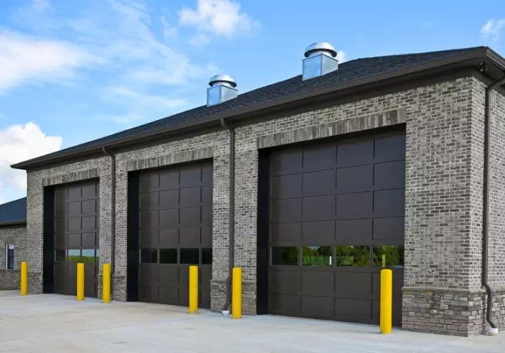 Modern industrial building with large garage doors and a clear blue sky commercial garage door for a business