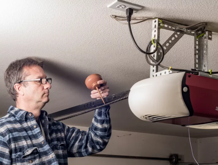 Certified technician performing garage door repairs.