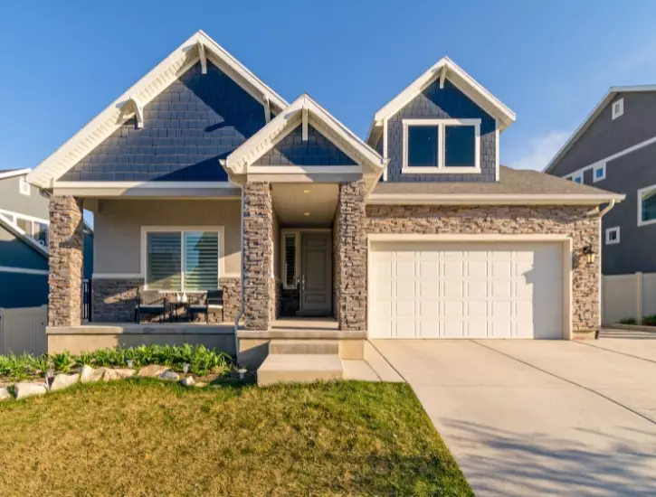 Beautiful suburban house with modern architecture and well-maintained front yard in the afternoon sun new modern residential garage door